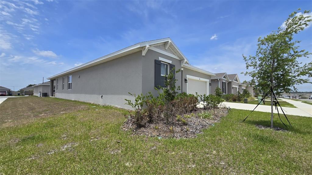 A gray single-story house with a two-car garage and a landscaped front yard — 802 BALLANTYNE DRIVE, LAKE WALES, FL