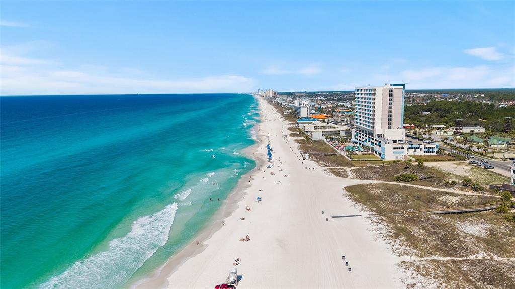 An aerial view of a white sand beach with a tall hotel and turquoise water — 112 BETH STREET, PANAMA CITY BEACH, FL