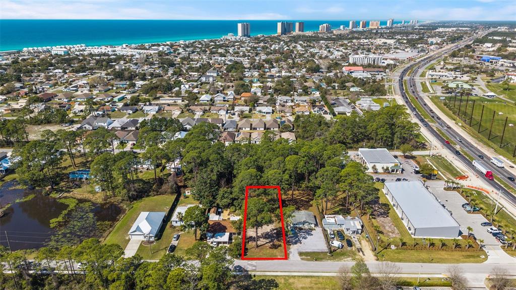 An aerial view shows a rectangular vacant lot outlined in red amidst a residential area — 112 BETH STREET, PANAMA CITY BEACH, FL
