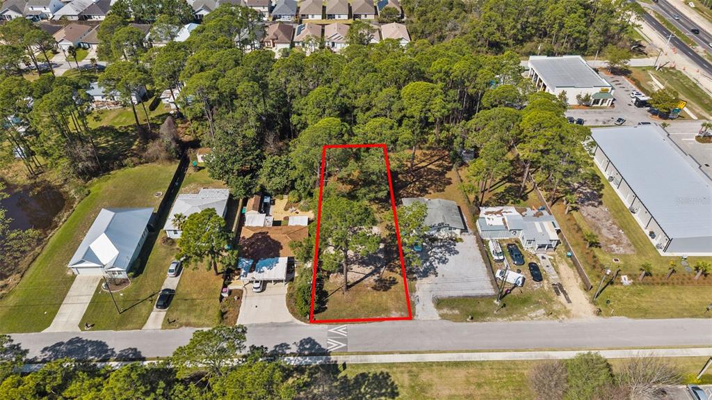 An aerial view shows a vacant, wooded lot outlined in red between two residential properties — 112 BETH STREET, PANAMA CITY BEACH, FL