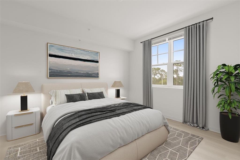 A bedroom features a bed with a beige headboard, gray bedding, and a large window — 5587 MILLENIA PARK BOULEVARD UNIT 308, ORLANDO, FL