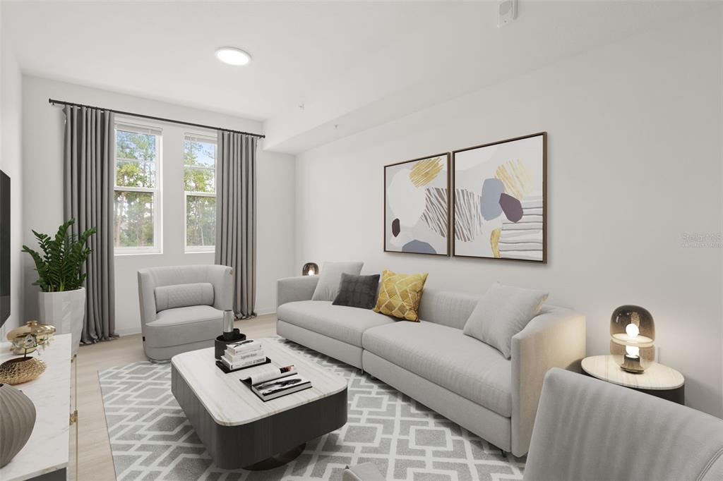 A modern living room features a light gray sofa, a patterned rug, and abstract wall art — 5587 MILLENIA PARK BOULEVARD UNIT 308, ORLANDO, FL