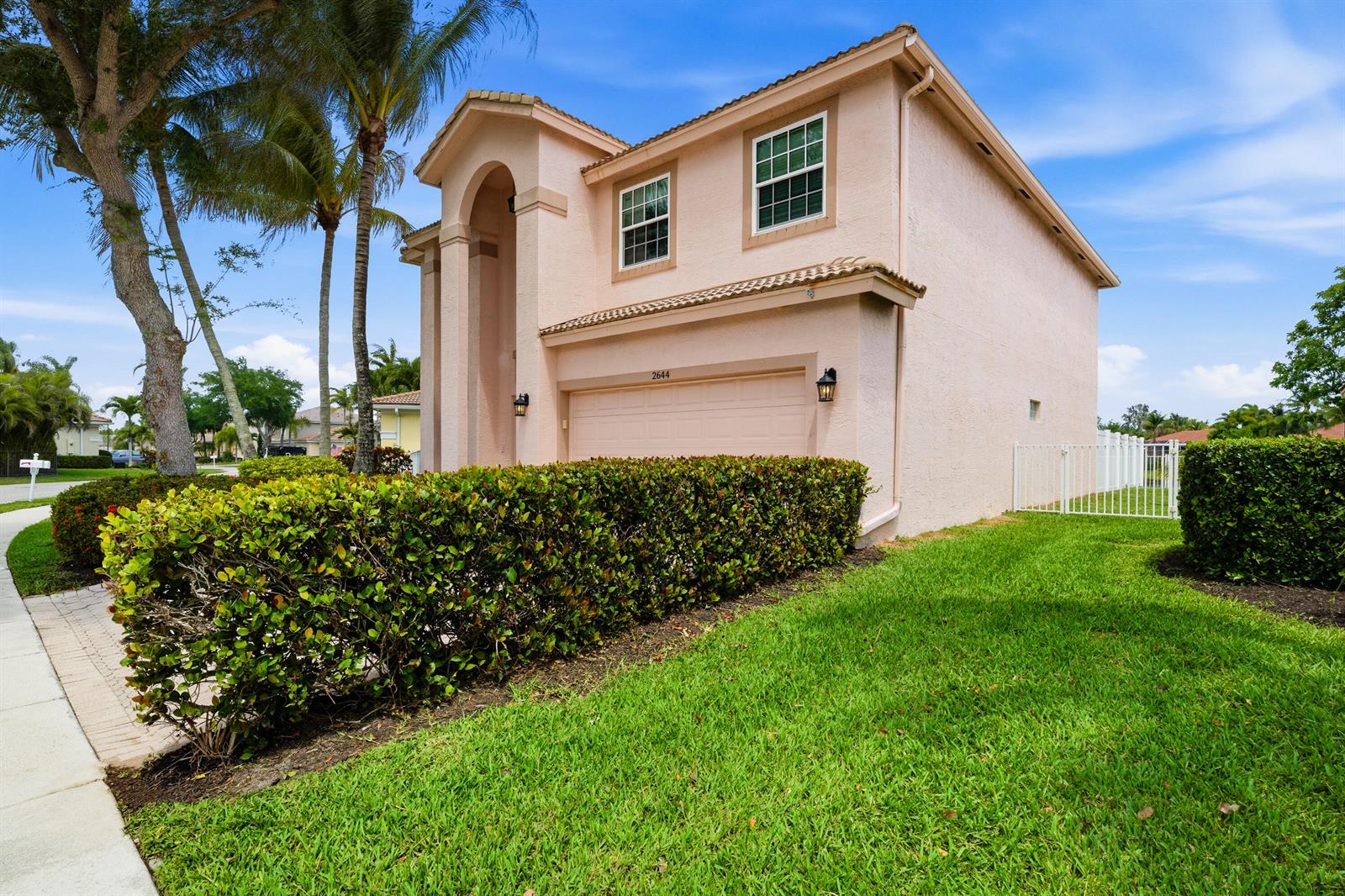 A two-story house with a light pink stucco exterior and a paved driveway — 2644 San Andros, West Palm Beach FL 33411, WEST PALM BEACH, FL