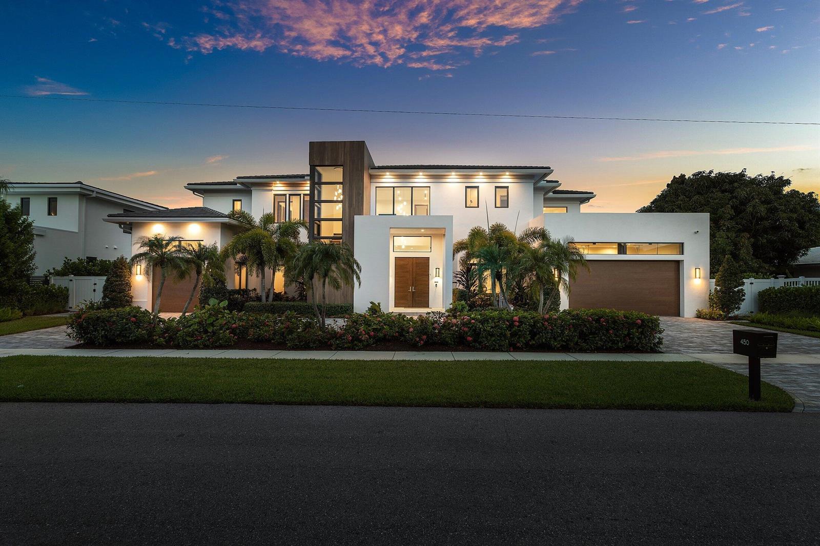 A modern two-story white house with wood accents, palm trees, and two attached garages at dusk — 450 NE 10th Street, Boca Raton FL 33432, BOCA RATON, FL