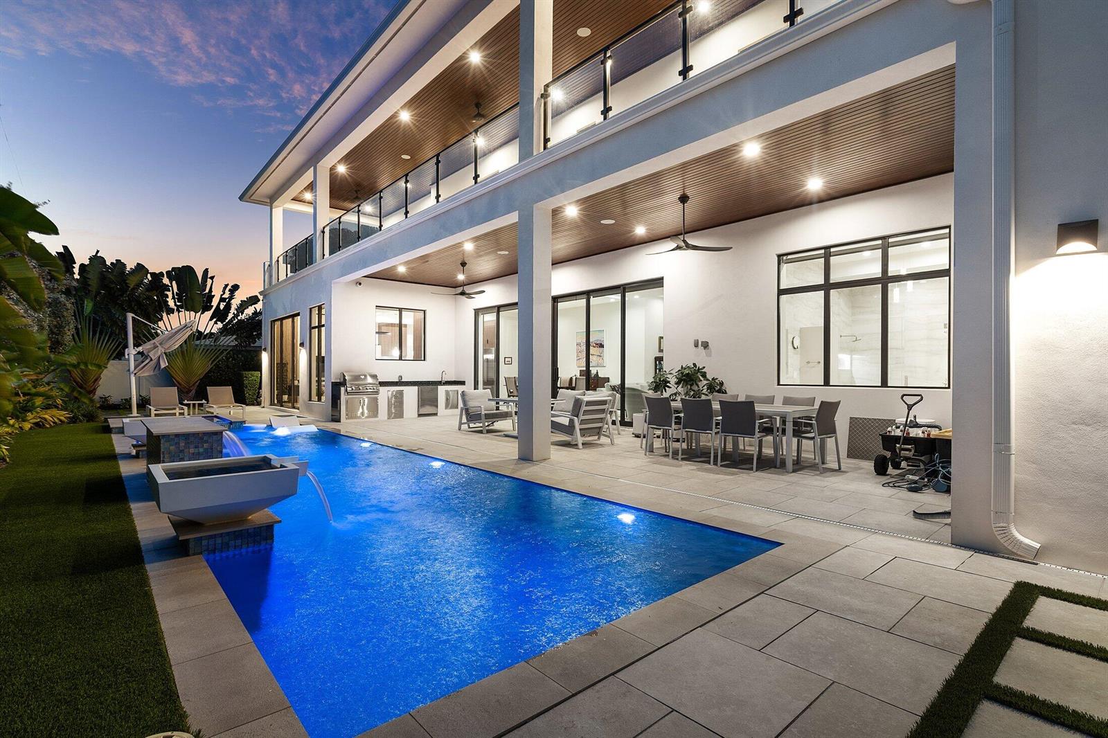 A modern two-story home exterior features a swimming pool, covered patio, and outdoor kitchen — 450 NE 10th Street, Boca Raton FL 33432, BOCA RATON, FL