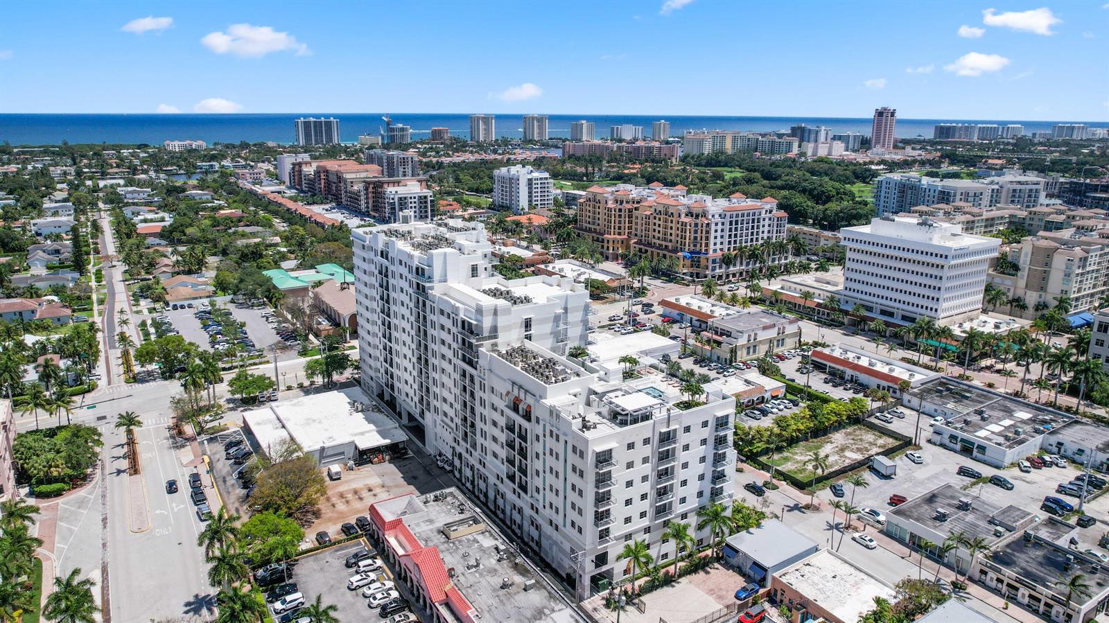 An aerial view shows a large white apartment building surrounded by city streets and palm trees — 155 E Boca Raton Road Unit 703, Boca Raton FL 33432, BOCA RATON, FL