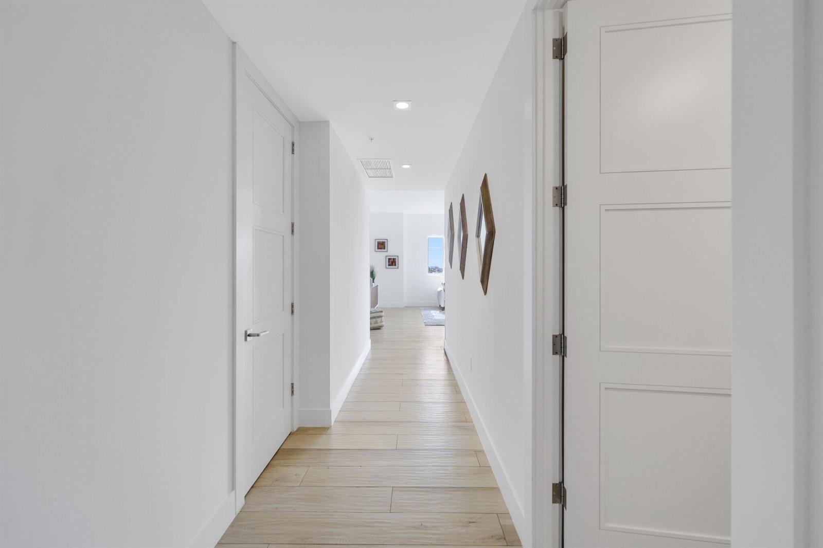 A bright hallway features white walls, light wood-look flooring, and several closed interior doors — 155 E Boca Raton Road Unit 703, Boca Raton FL 33432, BOCA RATON, FL