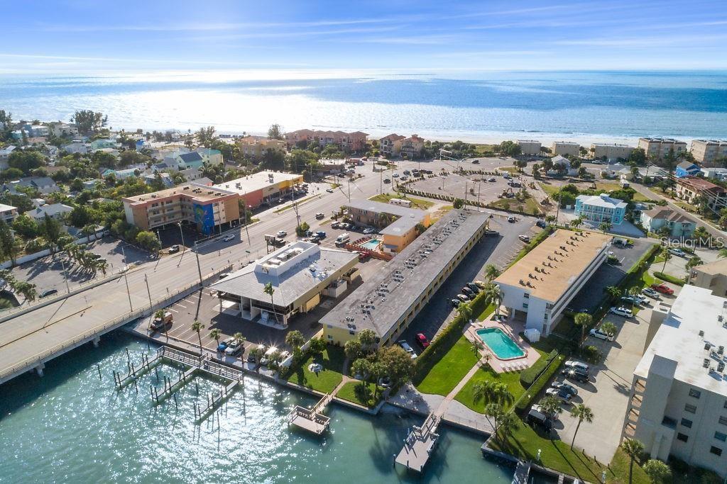 Aerial view of a coastal property featuring multiple buildings, a swimming pool, and a dock — 9715 HARRELL AVENUE UNIT 139, TREASURE ISLAND, FL