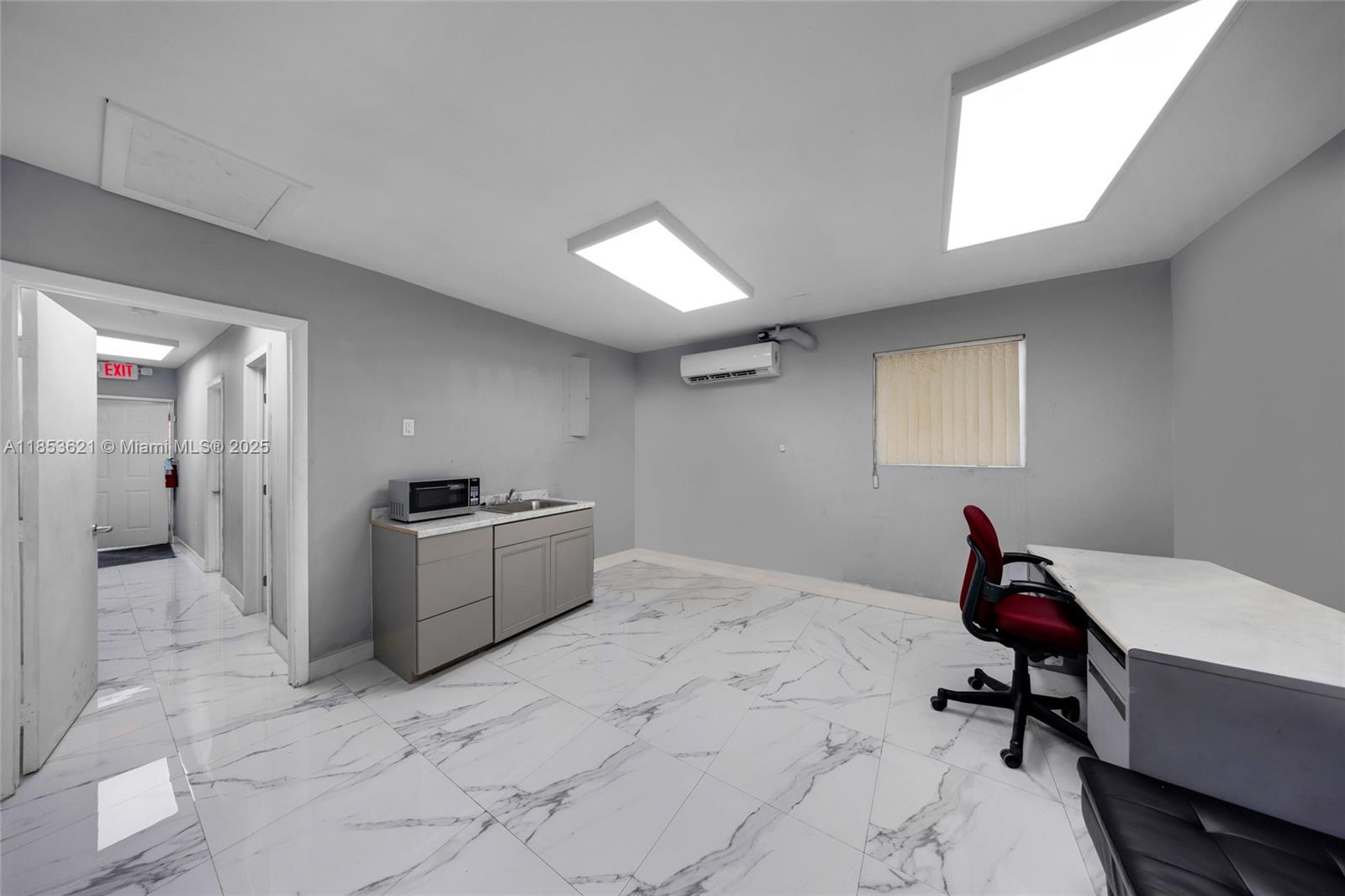 An office room features gray walls, white marble-patterned tile flooring, a kitchenette, and a desk — 2696 W 3rd Ave, Hialeah FL 33010, HIALEAH, FL