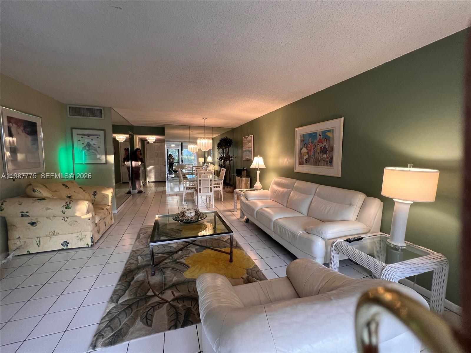 A living room features white leather furniture, a floral armchair, and a glass coffee table — 4387 Trevi Ct # 107, Lake Worth FL 33467, LAKE WORTH, FL