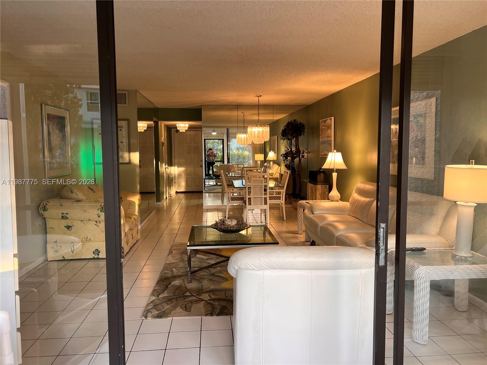A living and dining area features tiled floors, mirrored walls, and white leather furniture — 4387 Trevi Ct # 107, Lake Worth FL 33467, LAKE WORTH, FL