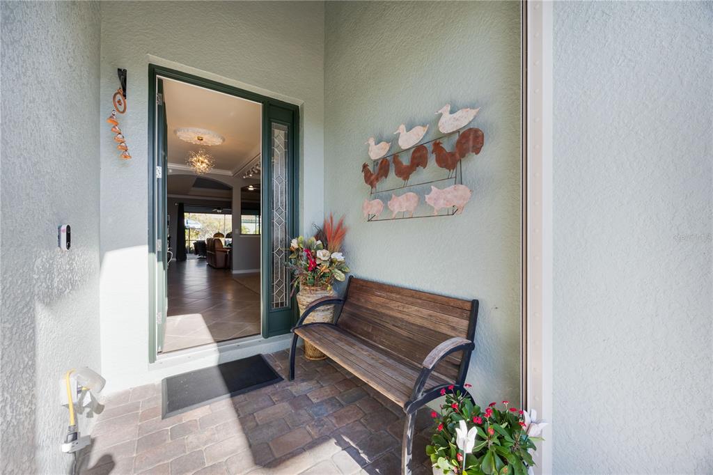 A bedroom features a queen bed, two nightstands, a bench, and coastal-themed wall art — 20700 GRANLAGO DRIVE, VENICE, FL