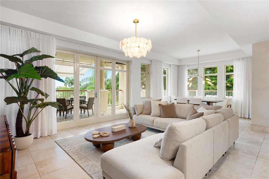 A bright living room features a large sectional sofa, a wooden coffee table, and patio access — 500 PLANTATION VILLAGE DRIVE UNIT 3-208, DORADO, PR