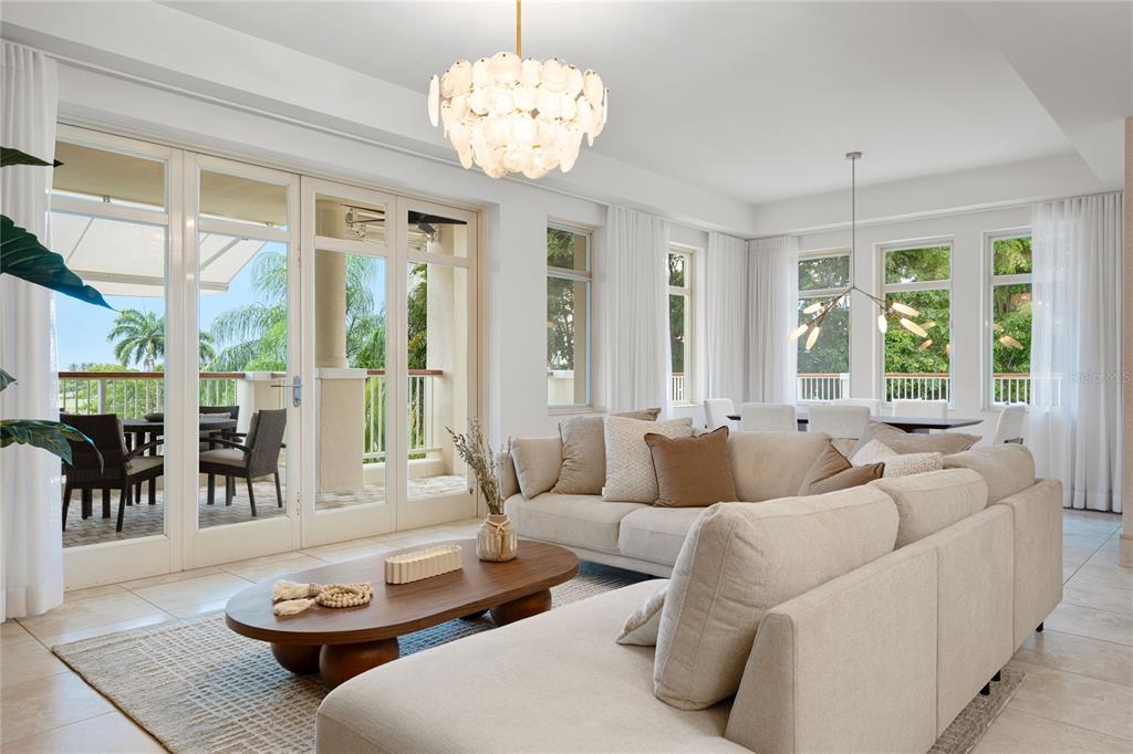 A bright living room features a large sectional sofa, a wooden coffee table, and patio access — 500 PLANTATION VILLAGE DRIVE UNIT 3-208, DORADO, PR