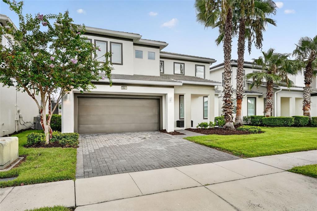 A two-story house with a two-car garage, paved driveway, and palm trees in the front yard — 2667 CALISTOGA AVENUE, KISSIMMEE, FL