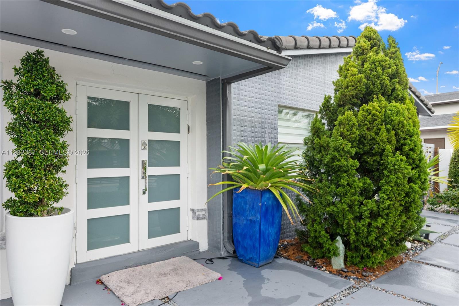 The exterior entrance features a double door with frosted glass panels and two large planters — 12721 SW 47th St, Miami FL 33175, MIAMI, FL