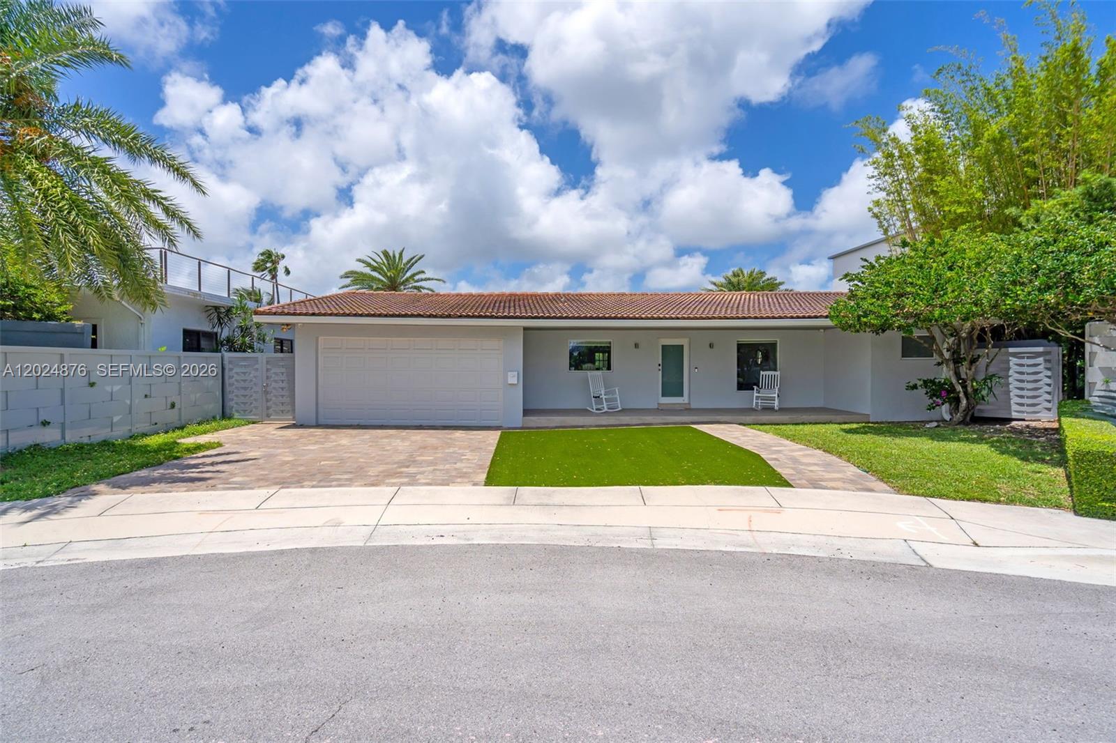 A single-story house with a tiled roof, garage, and a front porch with rocking chairs — 1261 NE 82nd St, Miami FL 33138, MIAMI, FL