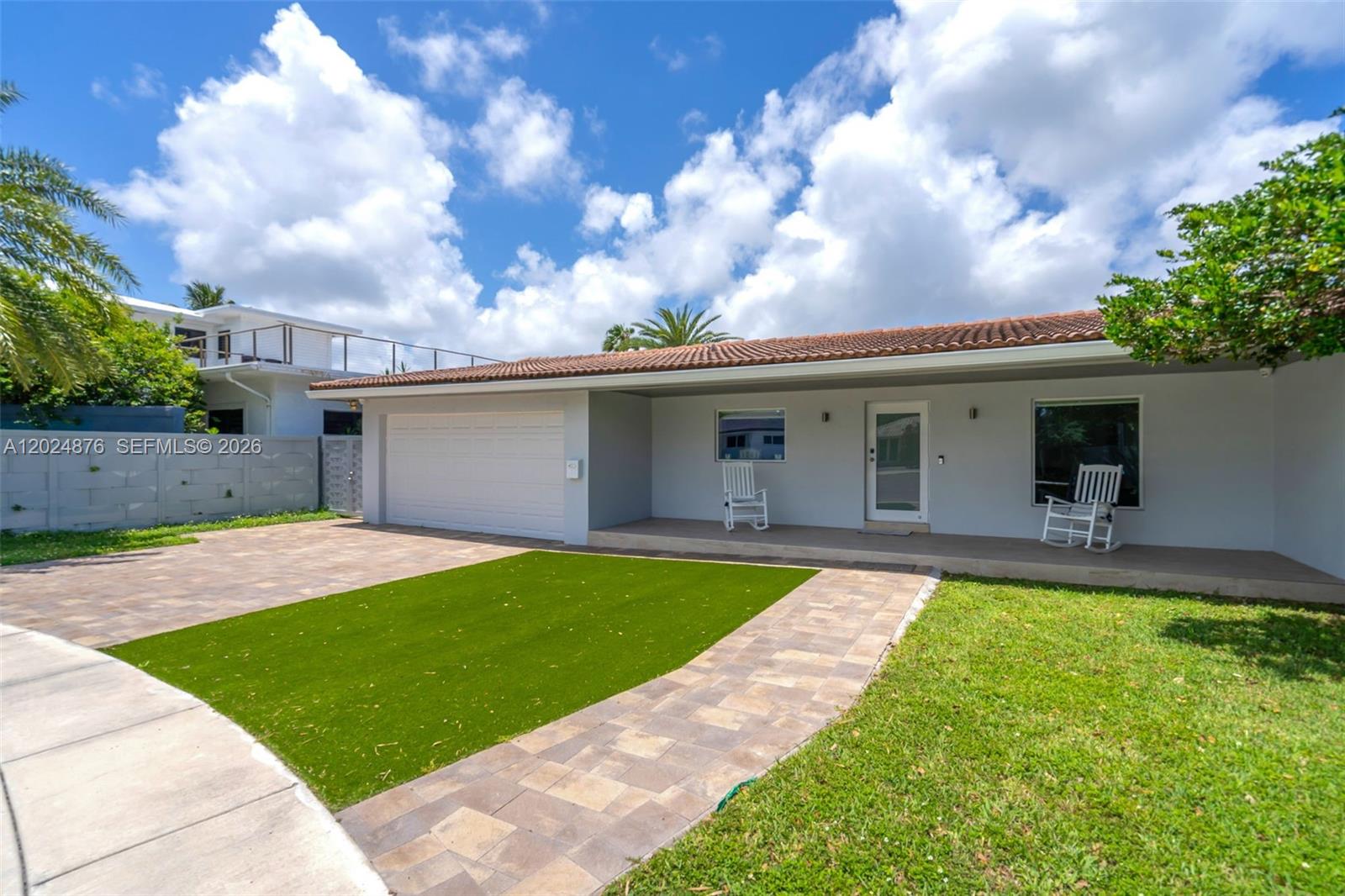 A single-story house features a paved driveway, artificial turf, and a covered front porch — 1261 NE 82nd St, Miami FL 33138, MIAMI, FL