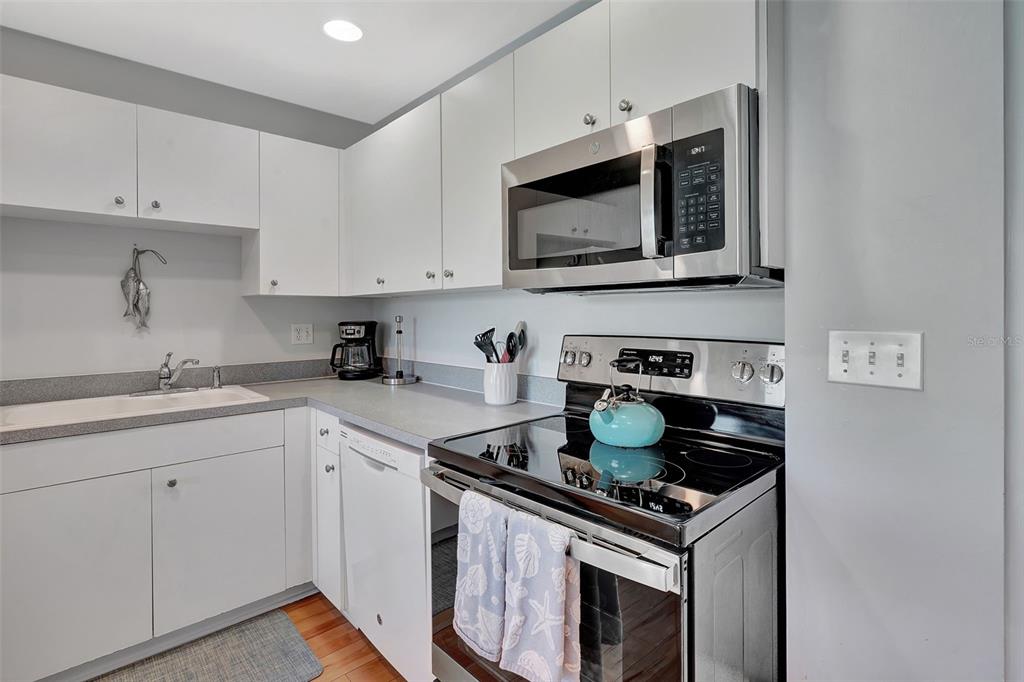 A kitchen features white cabinets, stainless steel appliances, and a light-colored countertop — 2090 MATECUMBE KEY ROAD UNIT 1207, PUNTA GORDA, FL