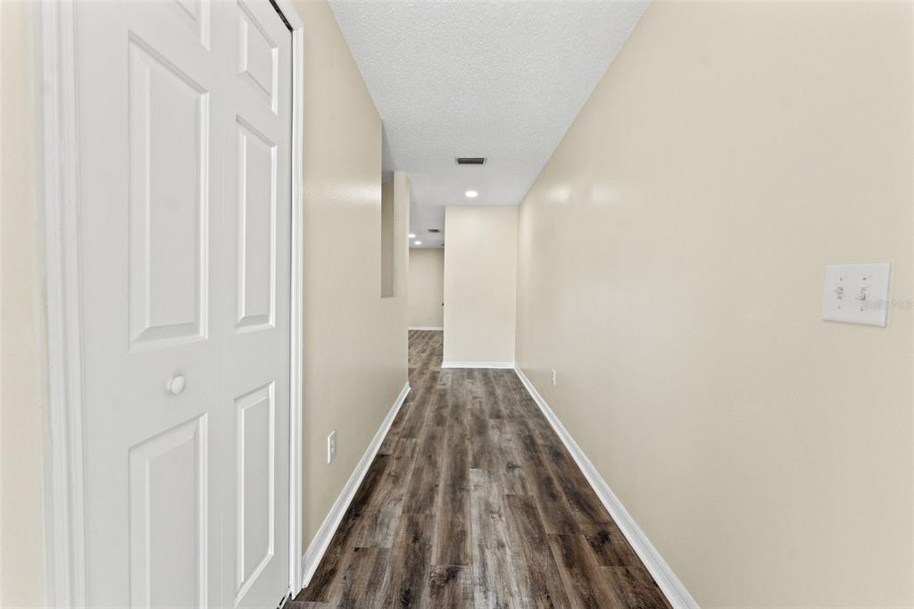 A kitchen features white cabinets, granite countertops, stainless steel appliances, and wood-look flooring — 8421 EDGEWATER PLACE BOULEVARD, TAMPA, FL