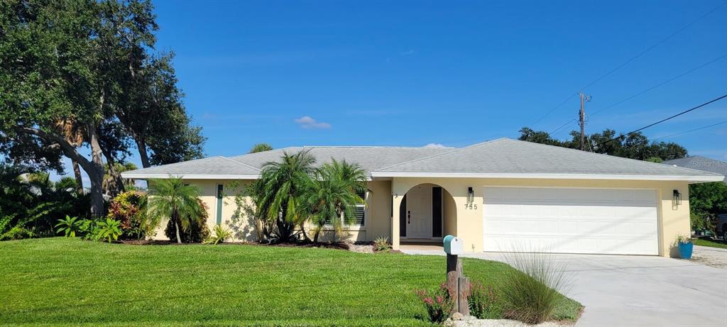 A single-story house with a light-colored exterior, a white garage door, and palm trees — 755 KENT ROAD, VENICE, FL