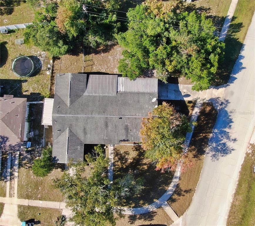 An aerial view shows a house with a shingled roof, a driveway, and surrounding trees — 1144 GERONA AVENUE, DELTONA, FL