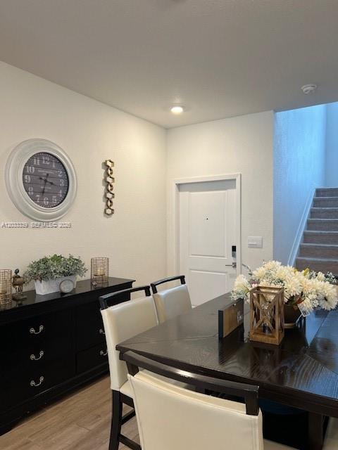 A dining area features a dark wood table, matching sideboard, and a wall-mounted clock — HOMESTEAD, FL