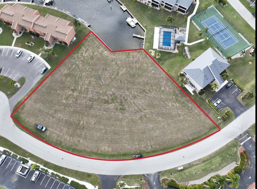An aerial view shows a vacant, trapezoidal waterfront lot outlined in red — 1341 ROCK DOVE COURT, PUNTA GORDA, FL