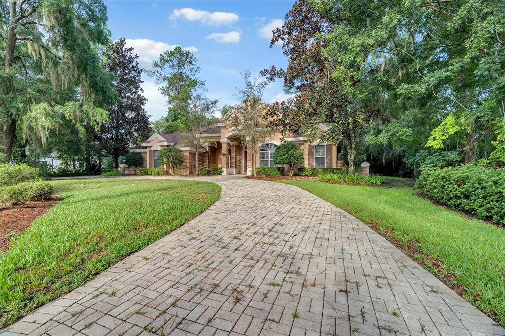 A paved driveway leads to the front entrance of a single-story house with stone accents — 5038 SE 6TH AVENUE, OCALA, FL