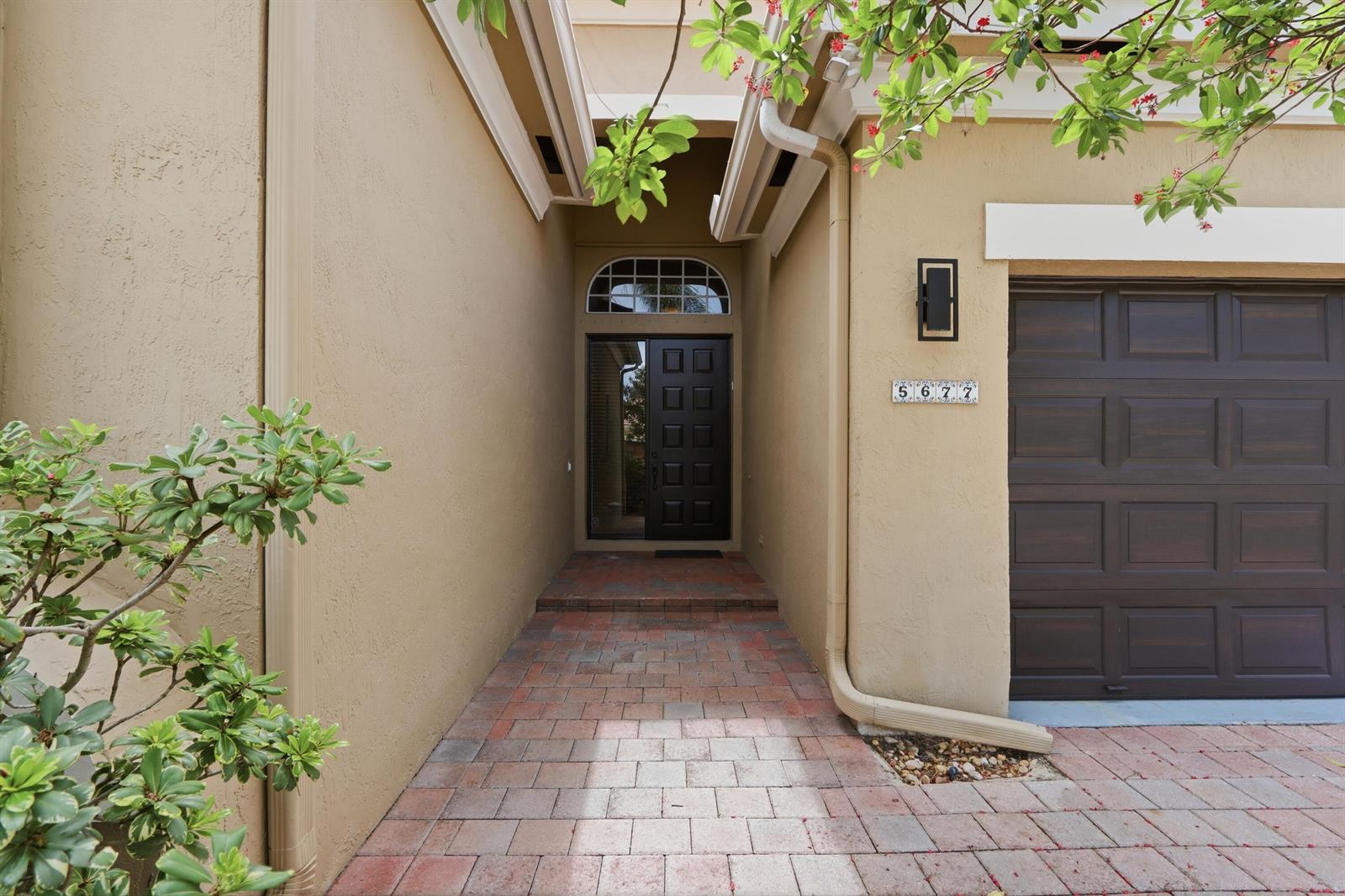 A screened-in patio features tiled flooring, outdoor furniture, a television, and a ping pong table — 5677 Via De La Plata Circle, Delray Beach FL 33484, DELRAY BEACH, FL