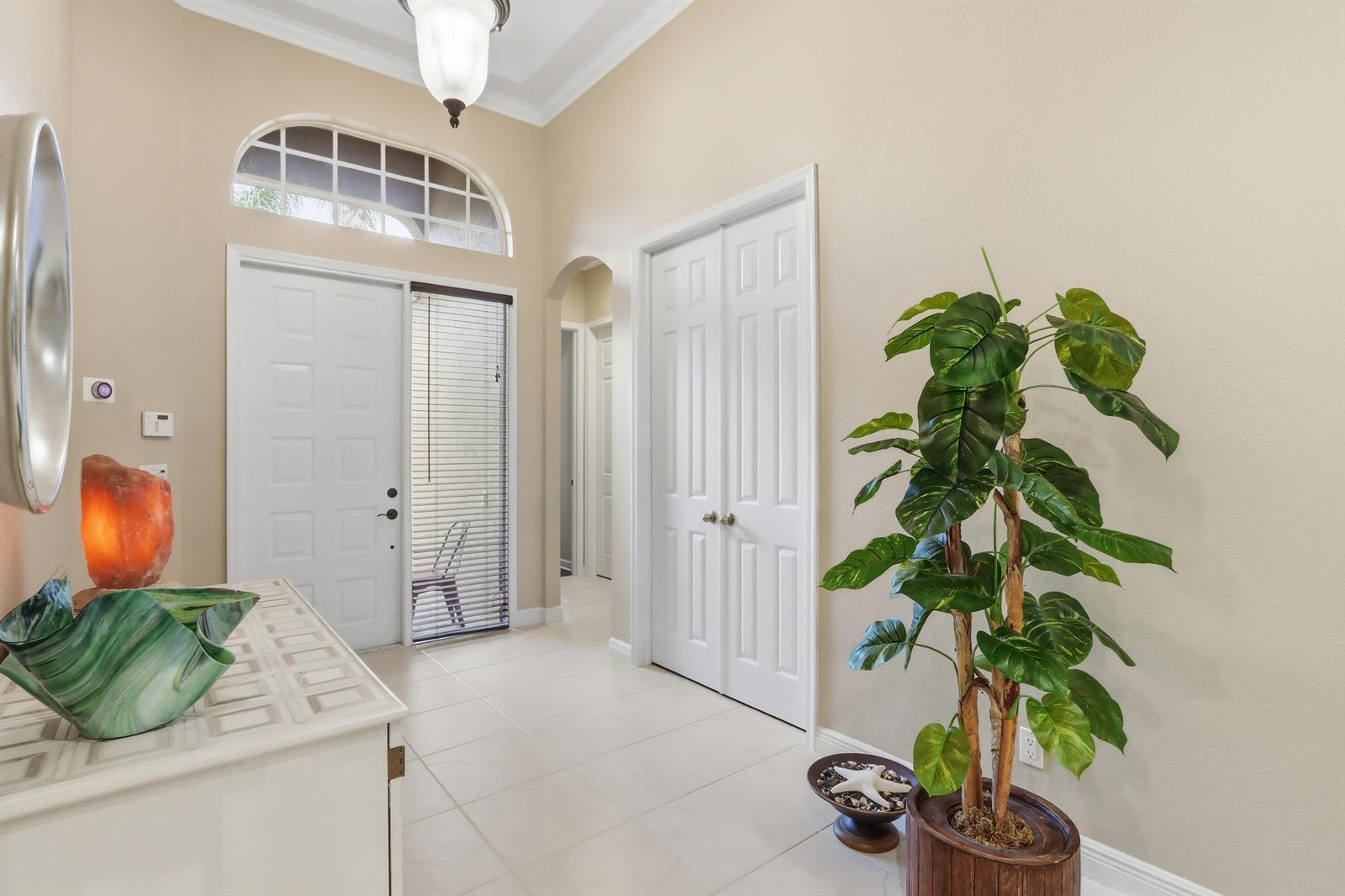 A single-story house with a tiled roof, a dark garage door, and a landscaped front yard — 5677 Via De La Plata Circle, Delray Beach FL 33484, DELRAY BEACH, FL
