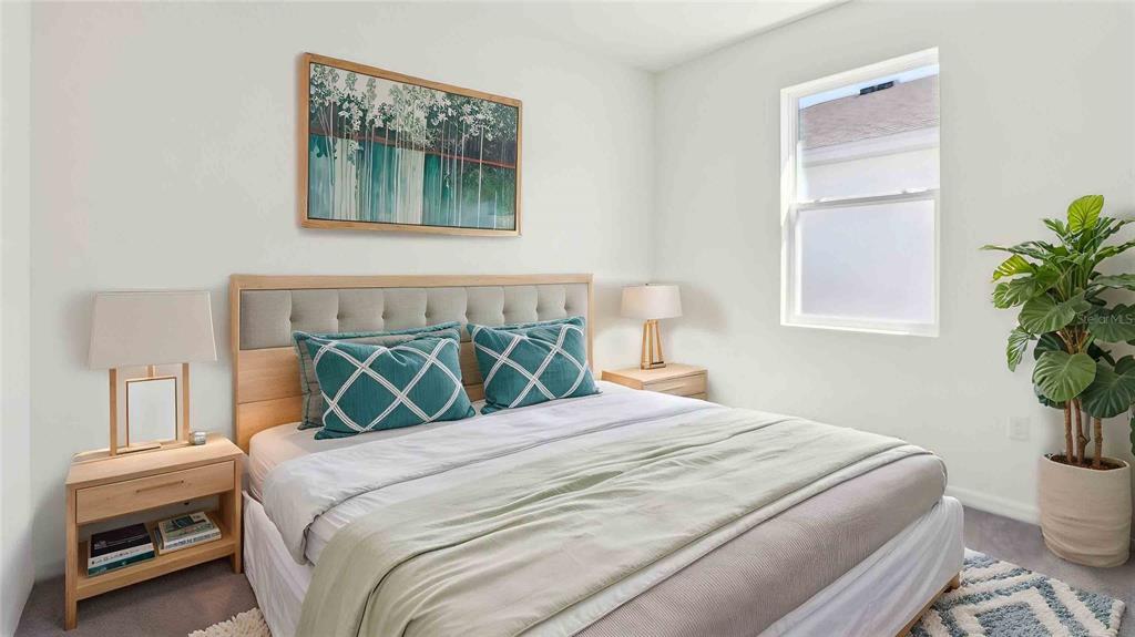 A bedroom features a bed with teal pillows, two nightstands with lamps, and a potted plant — 4832 NW 39TH PLACE, OCALA, FL