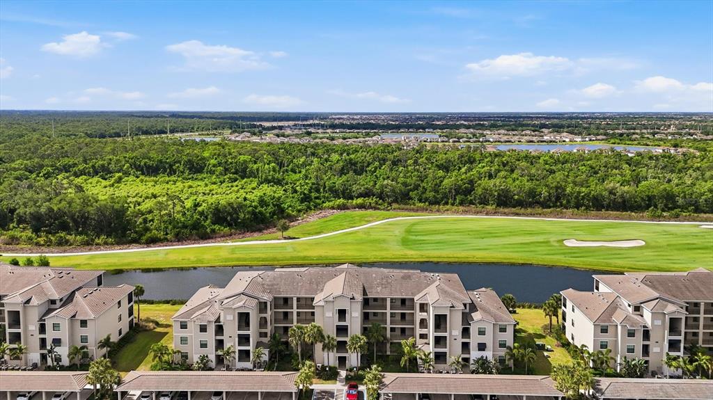 An aerial view of apartment buildings overlooking a golf course and a pond — 18008 GAWTHROP DRIVE UNIT 401, BRADENTON, FL