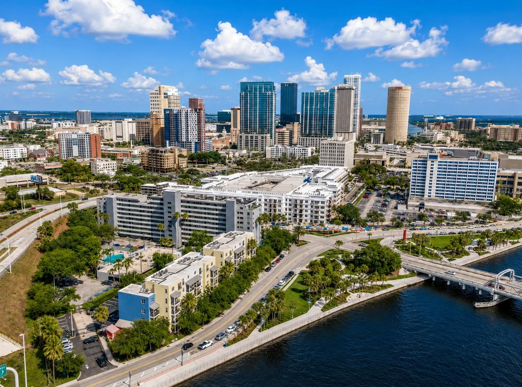 An aerial view shows a city skyline, a waterfront park, and nearby apartment buildings — 1501 DOYLE CARLTON DRIVE UNIT 411, TAMPA, FL