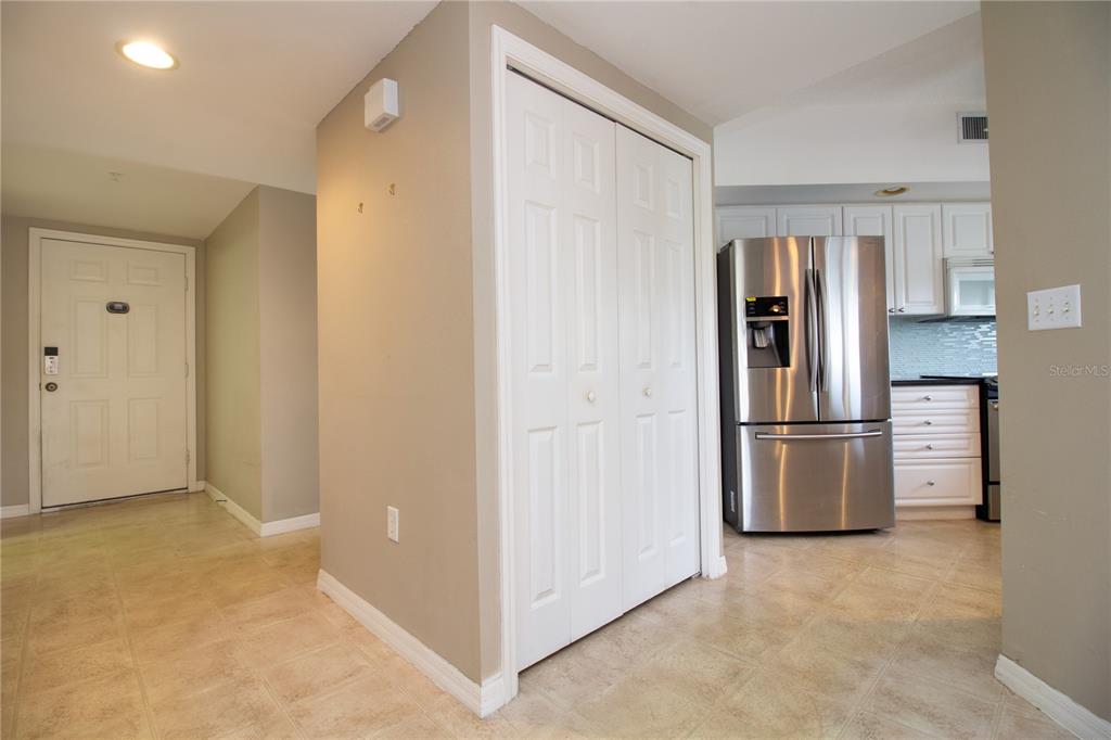 A view of an entryway with a closet, tile flooring, and an adjacent kitchen — 1200 COUNTRY CLUB DRIVE UNIT 1101, LARGO, FL