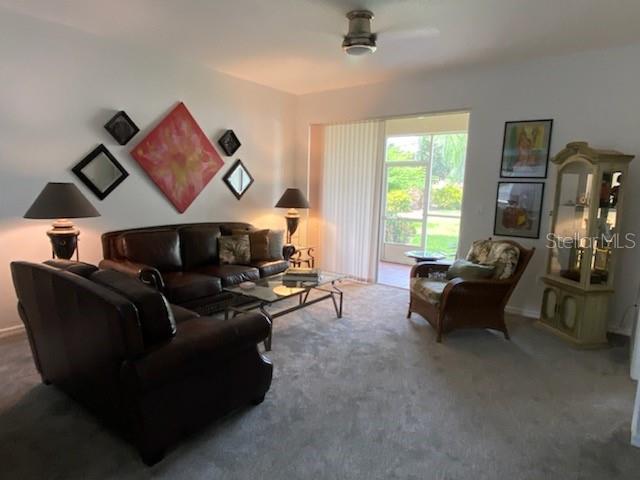 A living room features leather furniture, a glass coffee table, and a display cabinet — 8389 WINGATE DRIVE UNIT 2313B2, SARASOTA, FL
