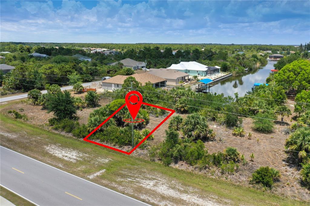 An aerial view shows a vacant, rectangular lot outlined in red beside a paved road — 14530 INGRAHAM BOULEVARD, PORT CHARLOTTE, FL
