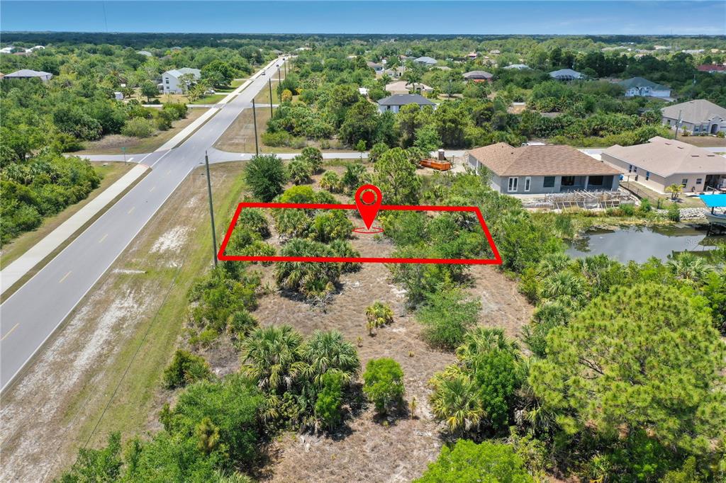 An aerial view shows a vacant, rectangular lot outlined in red next to a road — 14530 INGRAHAM BOULEVARD, PORT CHARLOTTE, FL