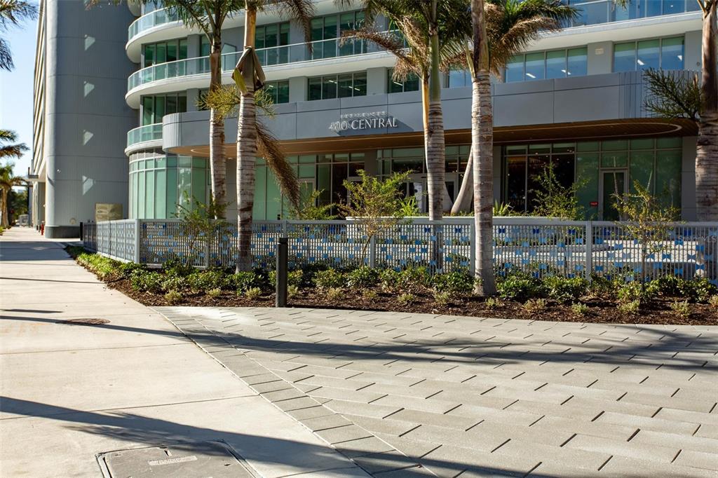 A modern multi-story building with a decorative metal fence and palm trees in front — 400 CENTRAL AVENUE UNIT 2601, ST PETERSBURG, FL