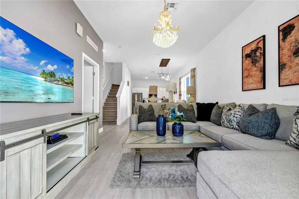 A living room features a sectional sofa, a coffee table, and a wall-mounted television — 240 FAMAGUSTA DRIVE, DAVENPORT, FL
