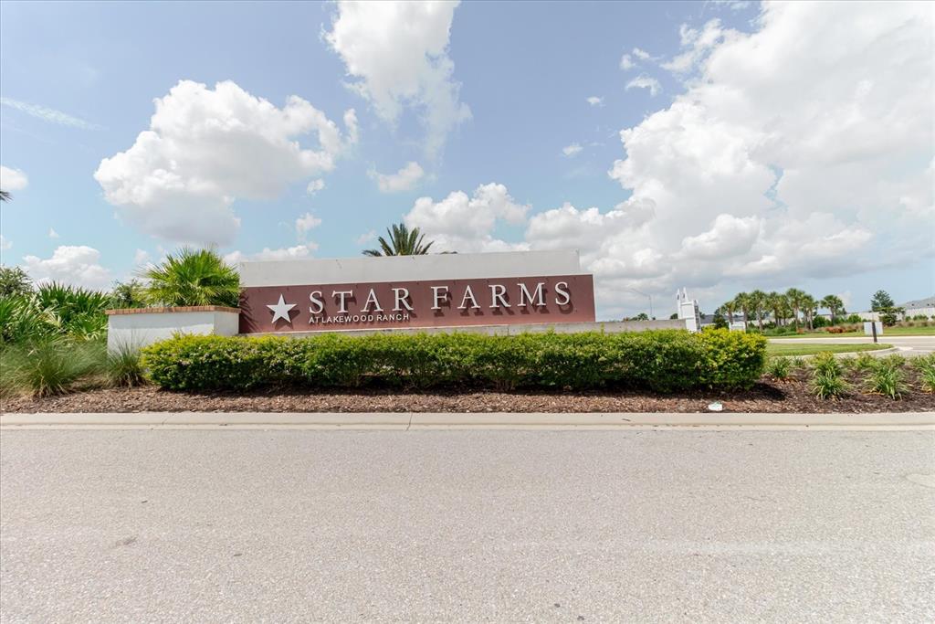 A sign for Star Farms at Lakewood Ranch stands behind a manicured hedge — 16725 BARNWOOD PLACE, BRADENTON, FL