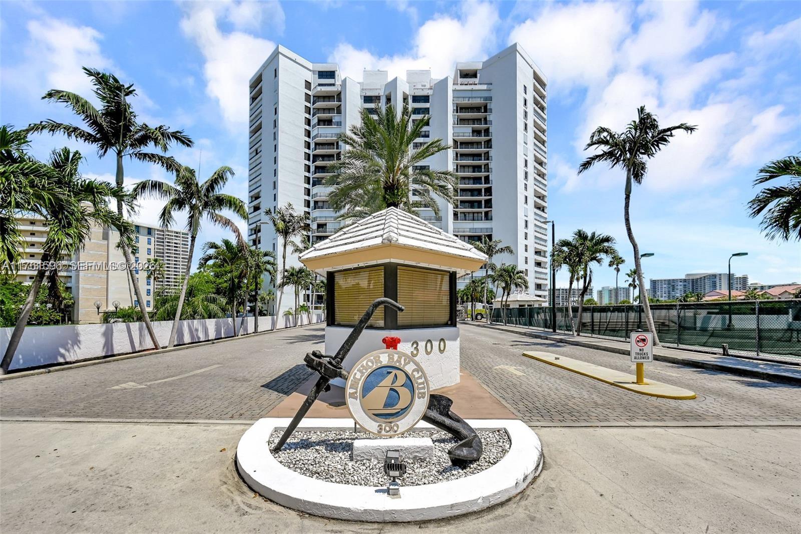 A security gatehouse with an anchor sculpture sits in front of a tall residential building — 300 Three Islands Blvd # 108, Hallandale Beach FL 33009, HALLANDALE BEACH, FL
