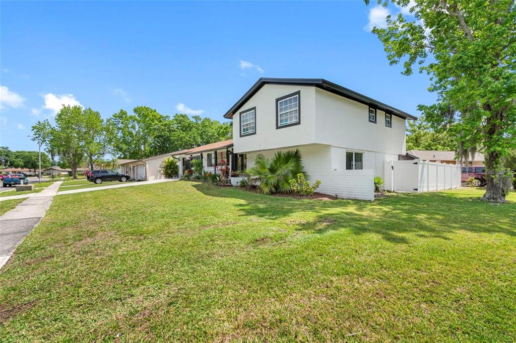 A two-story house with white exterior walls and a dark roof sits on a lawn — 16513 SILVERHILL DRIVE, TAMPA, FL