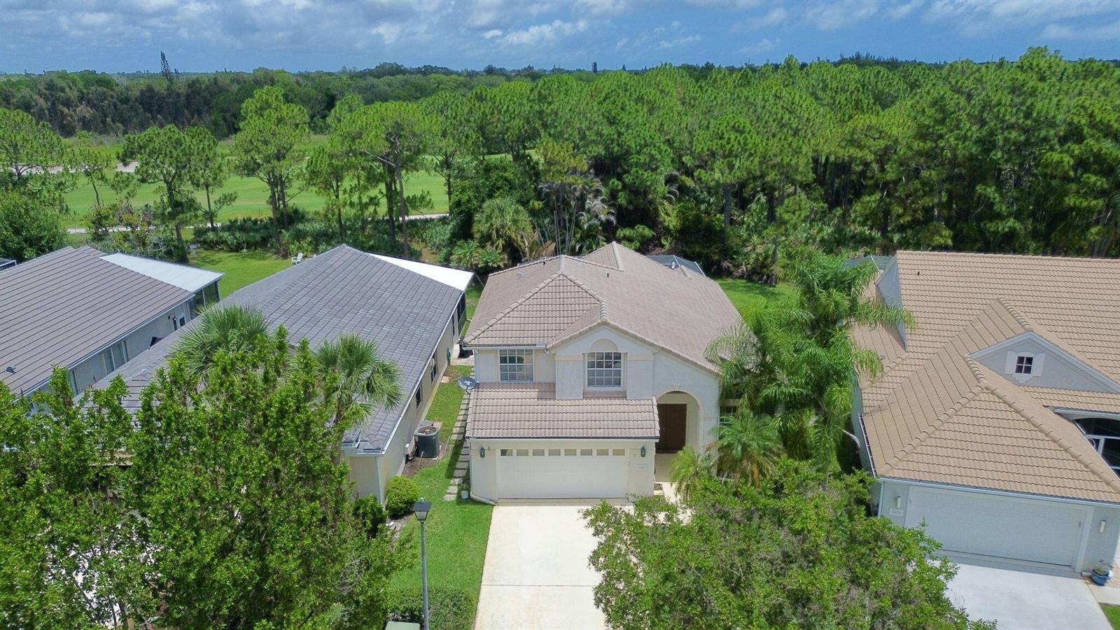 An aerial view shows a two-story house with a tiled roof and a concrete driveway — 6467 SE Wild Olive Lane, Stuart FL 34997, STUART, FL