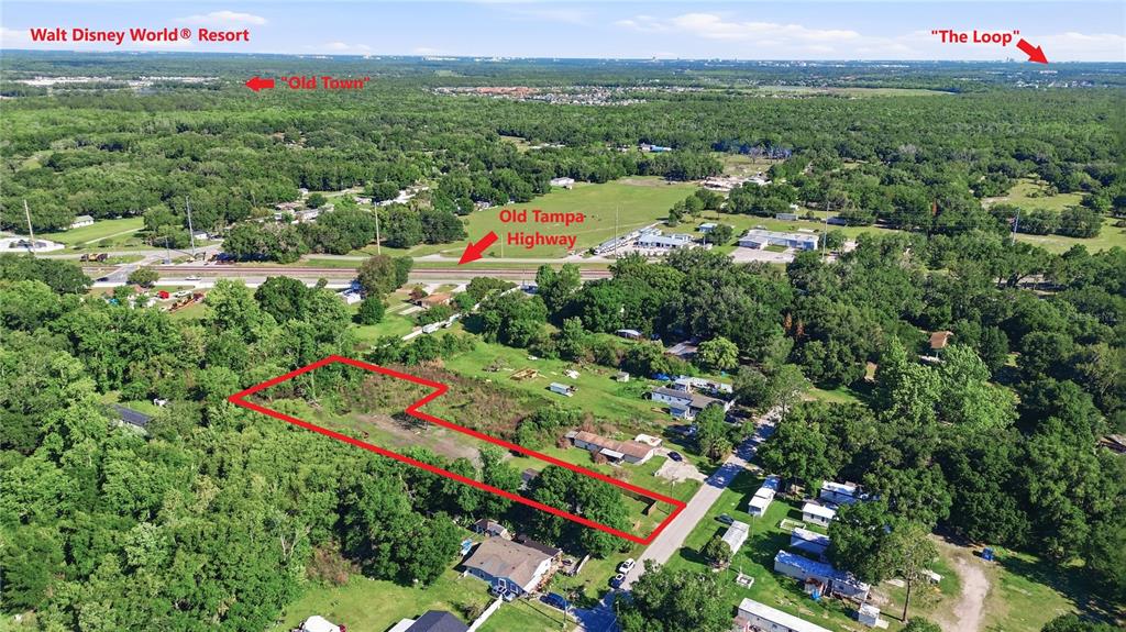 An aerial view shows a rectangular plot of land outlined in red near a highway — 1604 VINTAGE STREET, KISSIMMEE, FL
