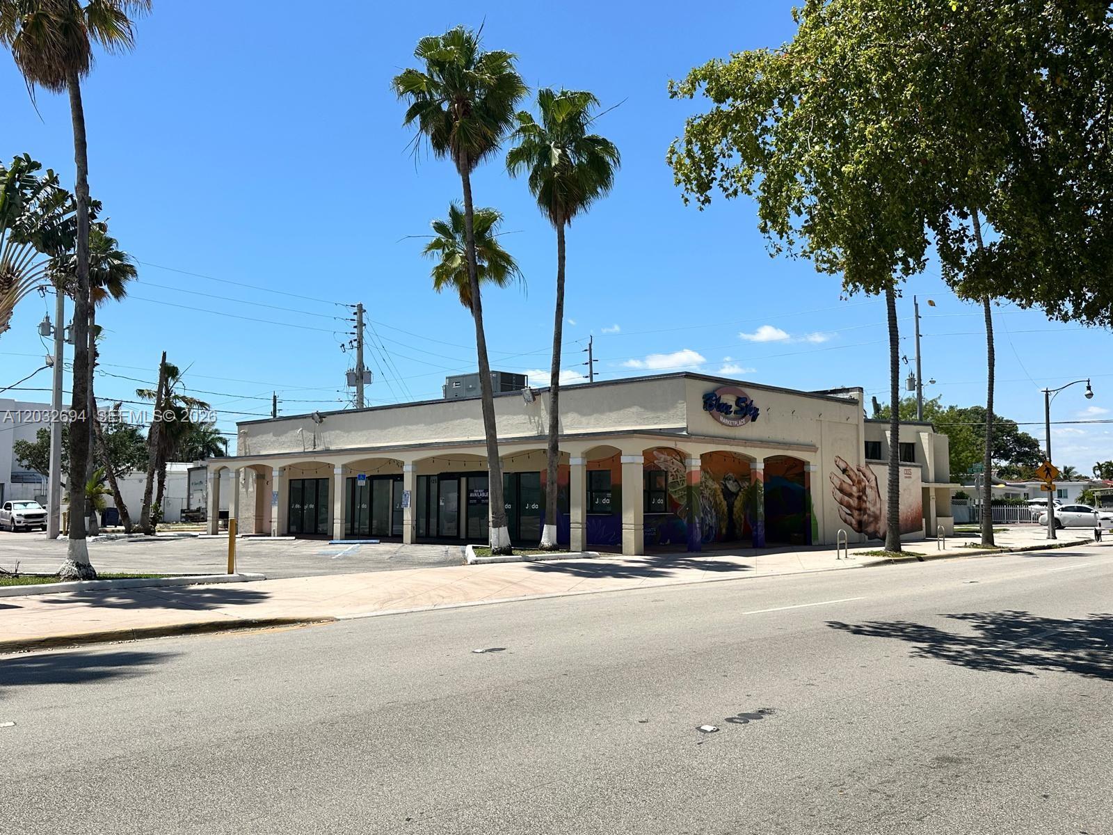 A single-story commercial building with a mural and palm trees sits along a paved street — 1250 Normandy DR, Miami Beach FL 33141, MIAMI BEACH, FL