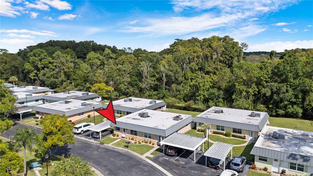 An aerial view shows a single-story residential building with a carport and surrounding green space — 11730 CARISSA LANE UNIT 0, NEW PORT RICHEY, FL