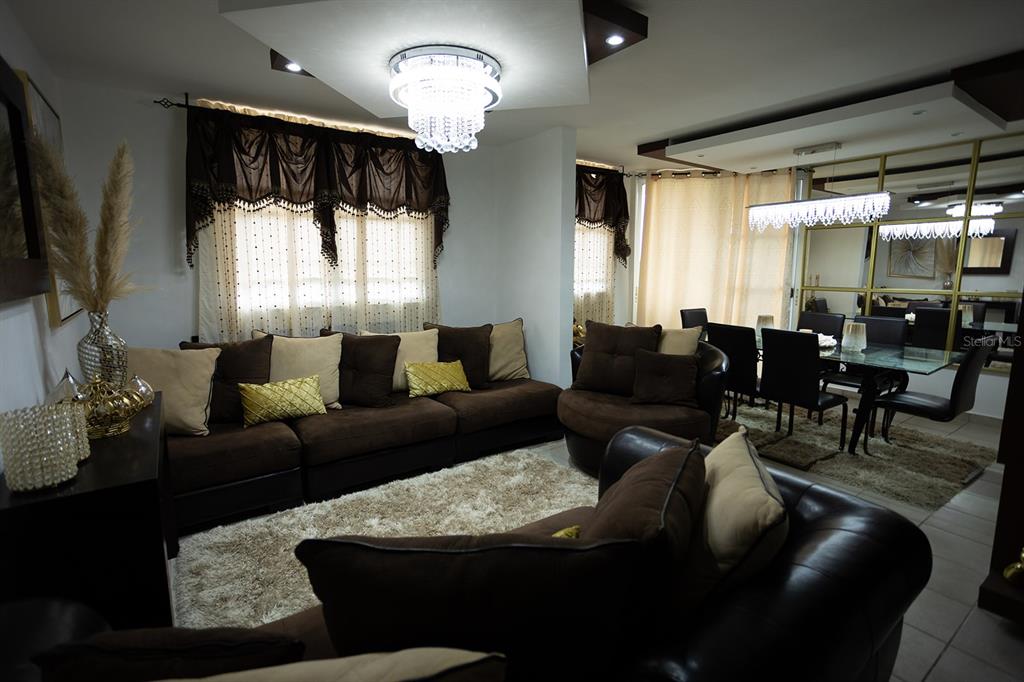 A living room with brown sofas, a shag rug, and a crystal chandelier — 686 PUERTO NUEVO UNIT 364, VEGA BAJA, PR