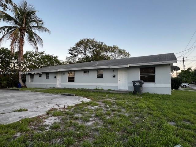 A single-story, light-colored residential building features a concrete driveway and a palm tree — 2746 Johnson St # w, Hollywood FL 33020, HOLLYWOOD, FL
