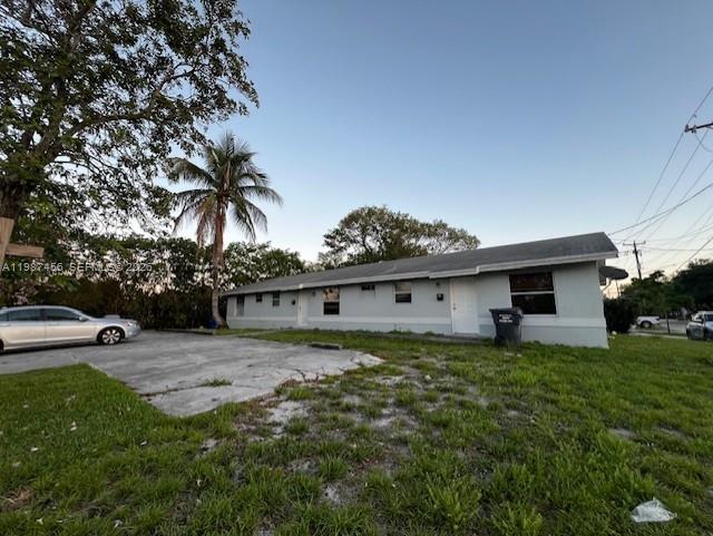 A single-story house with a light-colored exterior and a concrete driveway sits on a lawn — 2746 Johnson St # w, Hollywood FL 33020, HOLLYWOOD, FL
